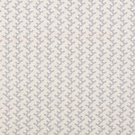 Panel of embroidered fabric in a linear geometric print in white and navy on a cream field.
