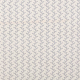 Panel of embroidered fabric in a linear geometric print in white and navy on a cream field.