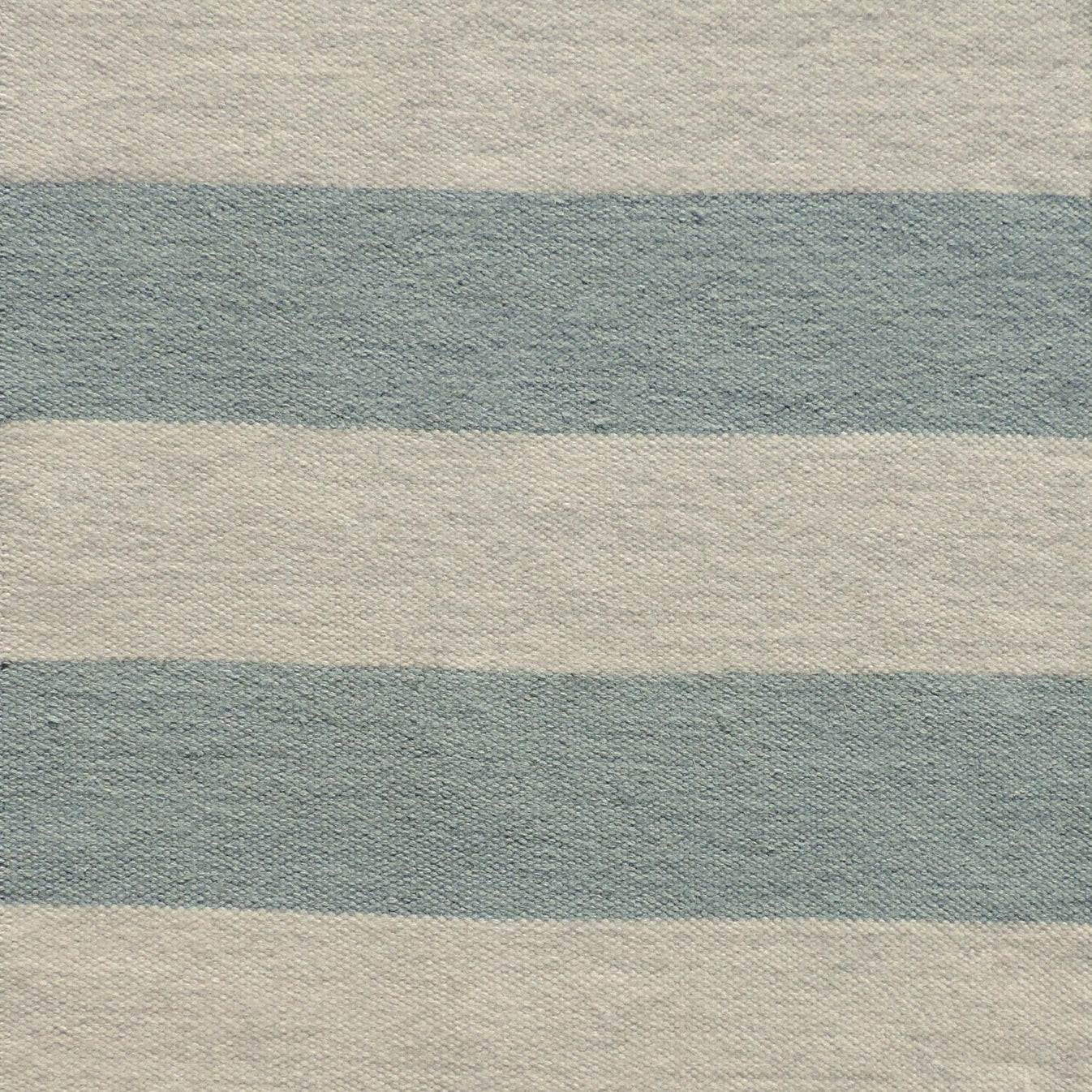 Handwoven rug with wide stripes in cream and light blue. 