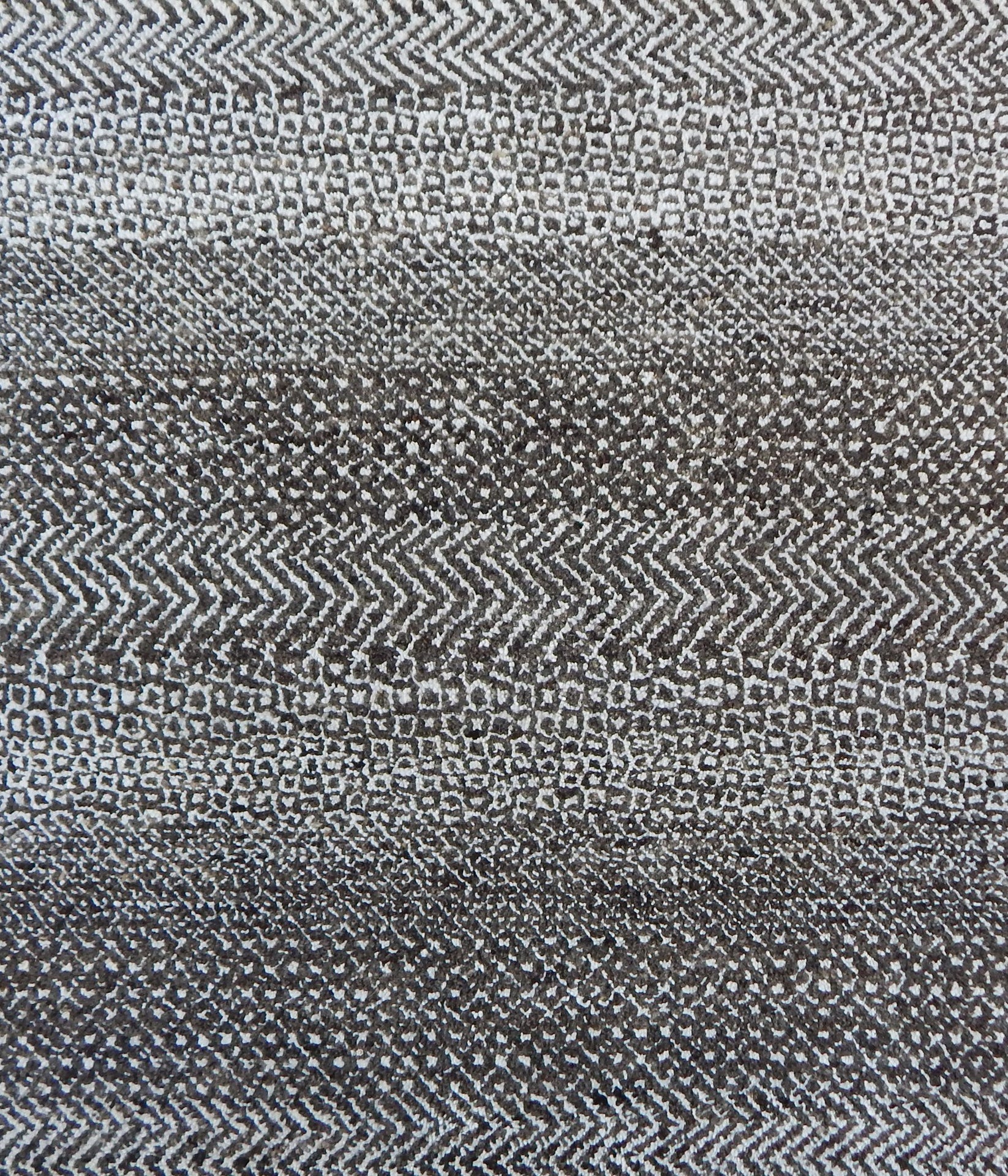 Handknotted rug with small scale geometric pattern in dark brown and ivory. 