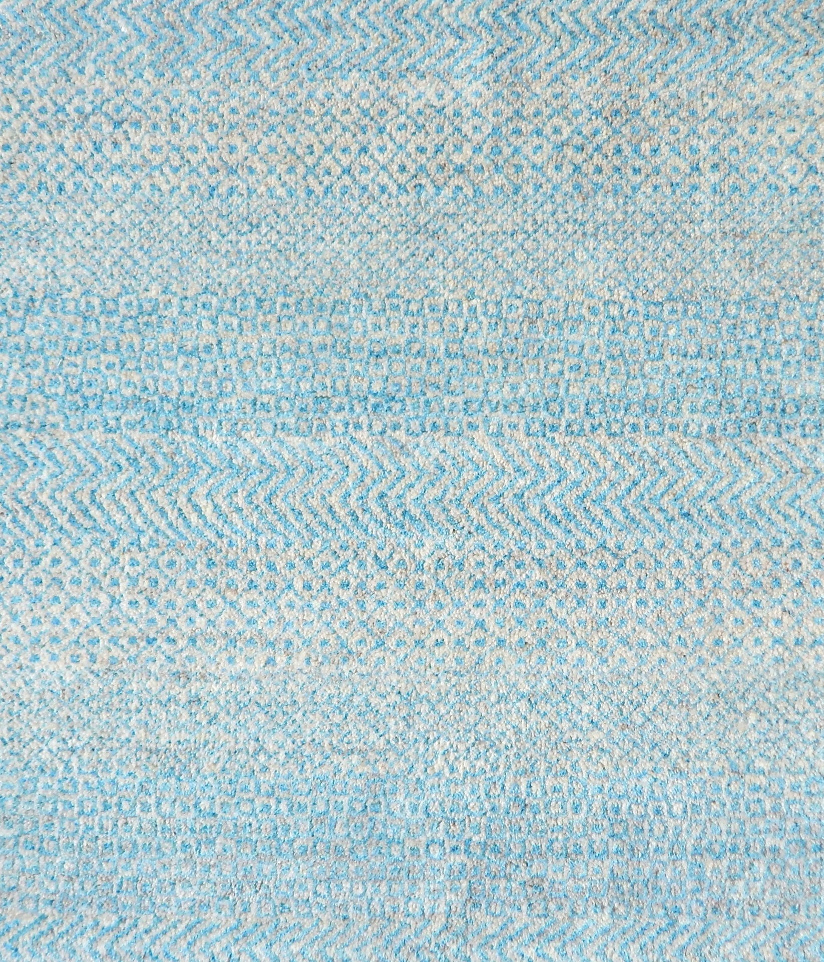 Handknotted rug with small scale geometric pattern in turquoise blue and pale grey. 
