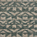 Handwoven rug detail in an angular geometric pattern in teal and beige.