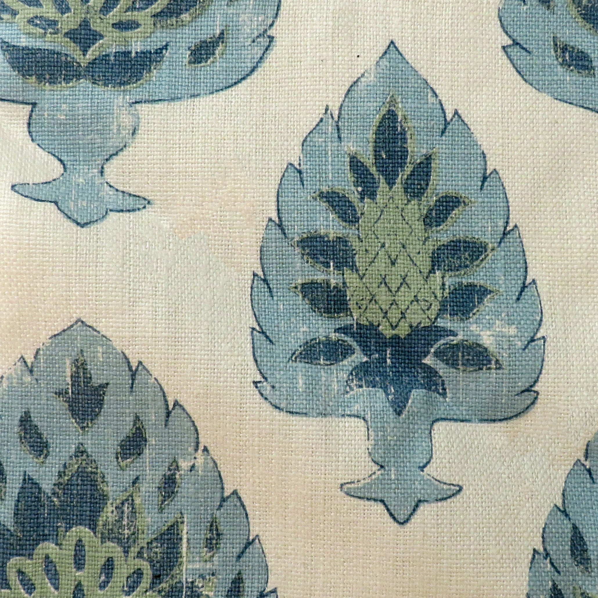 Detail of fabric in a botanical damask print in shades of green and blue on a cream field.