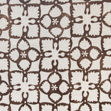 Detail of fabric in a botanical lattice print in brown on a cream field.