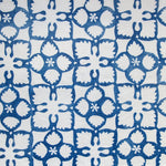 Detail of fabric in a botanical lattice print in blue on a white field.