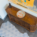 Overhead shot of a modernist living space with a cowhide rug in blue-gray with a tan geometric overlay.
