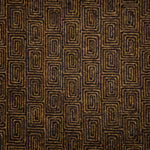 A close-up of flatweave rug  with a repeating geometric pattern in dark brown and tan. 
