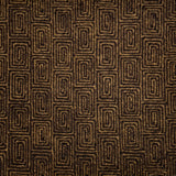 A close-up of flatweave rug  with a repeating geometric pattern in dark brown and tan. 