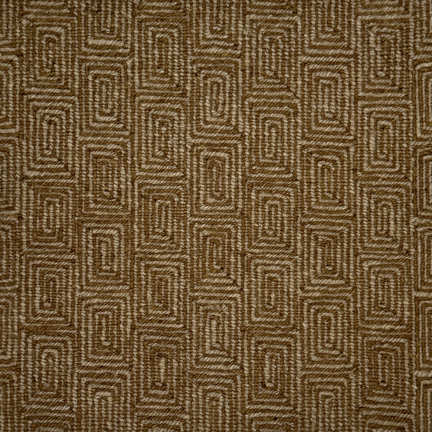A close-up of flatweave rug  with a repeating geometric pattern in dark brown and grey. 