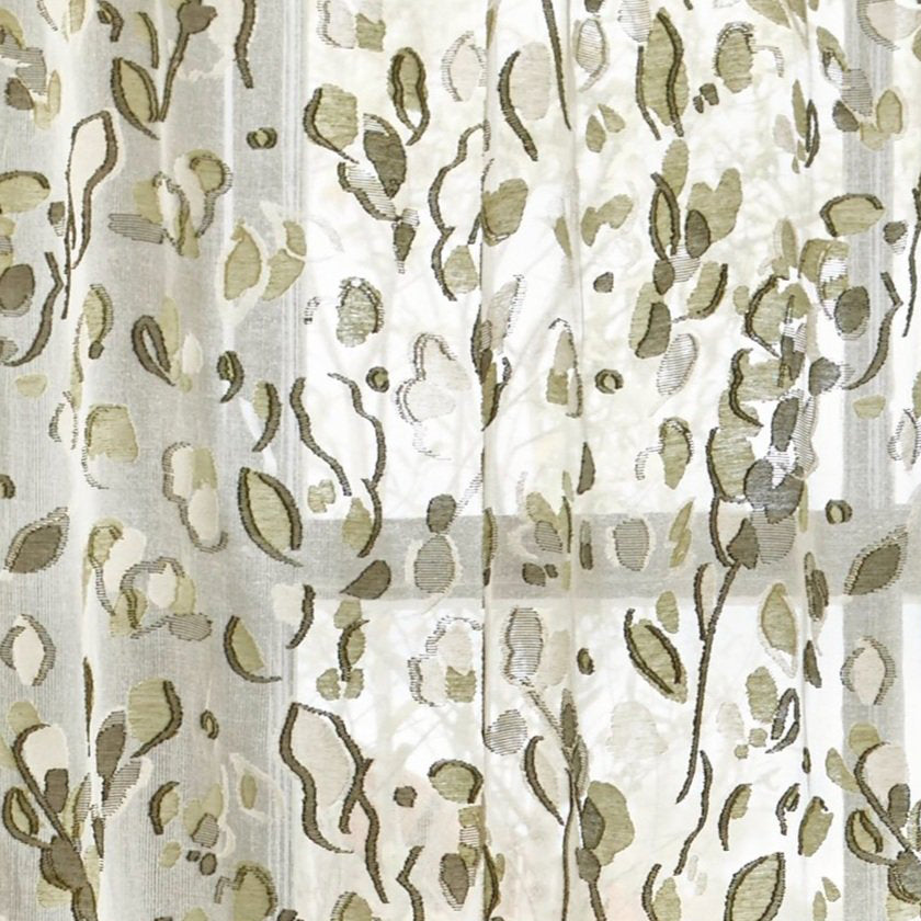 Detail of a draped sheer botanical patterned fabric in soft shades of green.