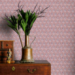 Vintage-style wallpaper with intricate patterns, a brass vase with greenery on a wooden dresser.