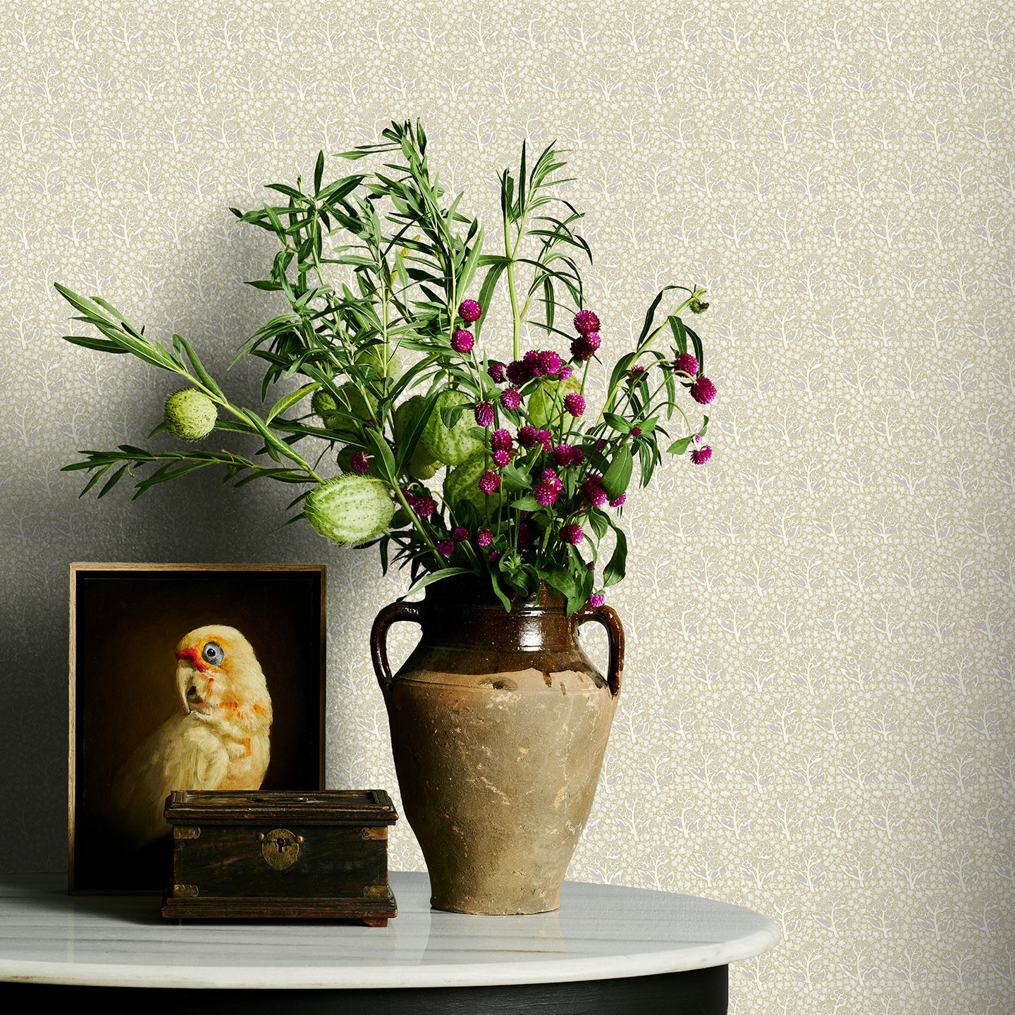 Vase with flowers on a table against a neutral floral wallpaper