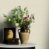 Vase with flowers on a table against a neutral floral wallpaper