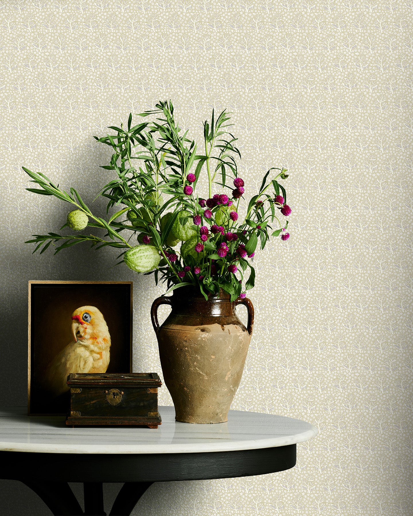 Vase with flowers on a table against a neutral floral wallpaper