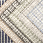 Broadloom carpet  samples stacked in a range of colors in a textural strie stripe.