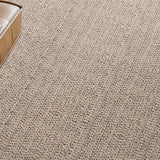 Wall to wall broadloom carpet in a textural taupe with a brown leather ottoman. 