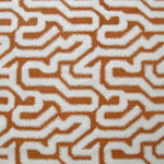 Detail of fabric in a playful meandering print in white on a copper field.