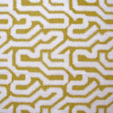 Detail of fabric in a playful meandering print in cream on a mustard field.