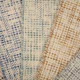 A pile of broadloom carpets in textural basket weaves in an array of colors. 