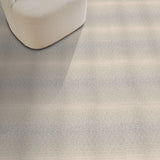 Textured gray carpet with a chair and red pillow in the corner