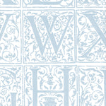 Detail of wallpaper in a playful alphabet grid print in light blue on a white field.