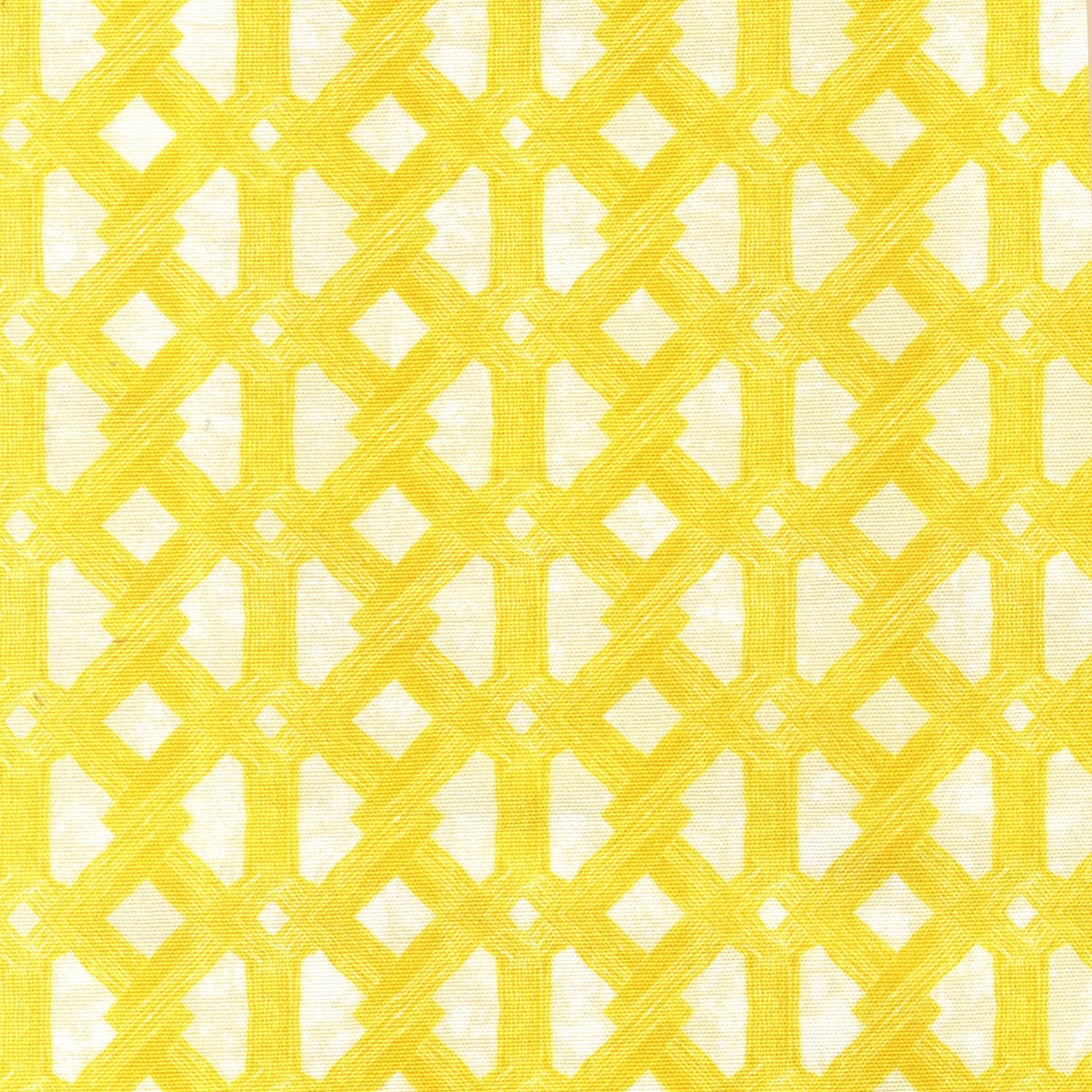Detail of fabric in an intricate lattice print in yellow on a cream field.