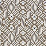 Detail of fabric in a floral damask print in white and black on a brown field.