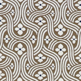 Detail of fabric in a floral damask print in white and black on a brown field.