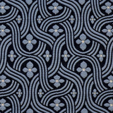 Detail of fabric in a floral damask print in blue and white on a black field.