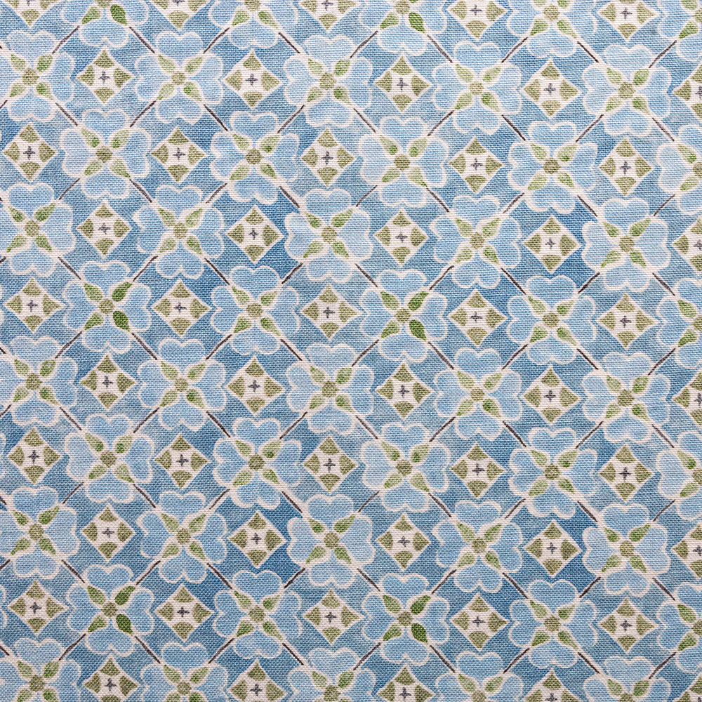 Detail of fabric in a floral lattice print in blue, green and white.