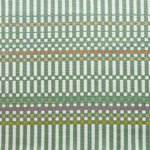 Detail of fabric in a dense irregular check print in green with red, yellow and purple accents on a white field.