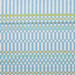 Detail of fabric in a dense irregular check print in light blue with yellow and green accents on a white field.