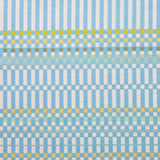 Detail of fabric in a dense irregular check print in light blue with yellow and green accents on a white field.