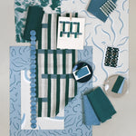 Layered mood board with printed fabrics, wallpapers, trims and swatches in shades of teal, blue, taupe and cream.