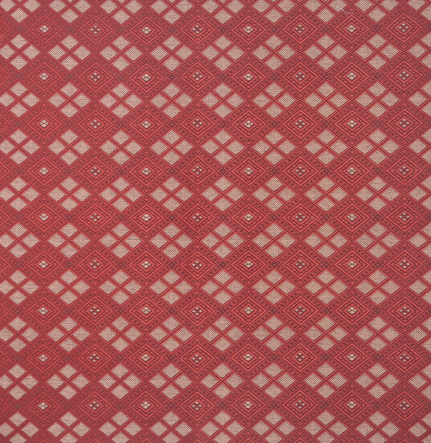 Woven fabric with ornate diamond design with cream accents on red