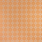 Woven fabric with ornate diamond design with cream accents on orange. 