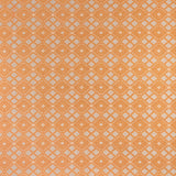 Woven fabric with ornate diamond design with cream accents on orange. 