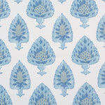 Detail of fabric in a botanical damask print in shades of green and blue on a cream field.