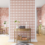 A maximalist living space with an accent wall papered in an intricate geometric stripe in shades of rust, gray and cream.
