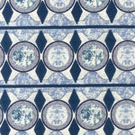 Detail of fabric in an intricate geometric stripe in shades of blue, navy and cream.