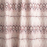 Draped fabric yardage in a painterly ikat print in shades of purple and pink on a white field.