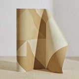 A curved partition stands on the ground, covered in a large-scale geometric print in cream and tan.