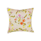 A throw pillow with a hand drawn brightly colored floral print on a light pink ground.