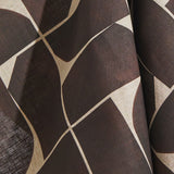 Draped fabric yardage in a large-scale curvilinear geometric print in brown on a cream field.