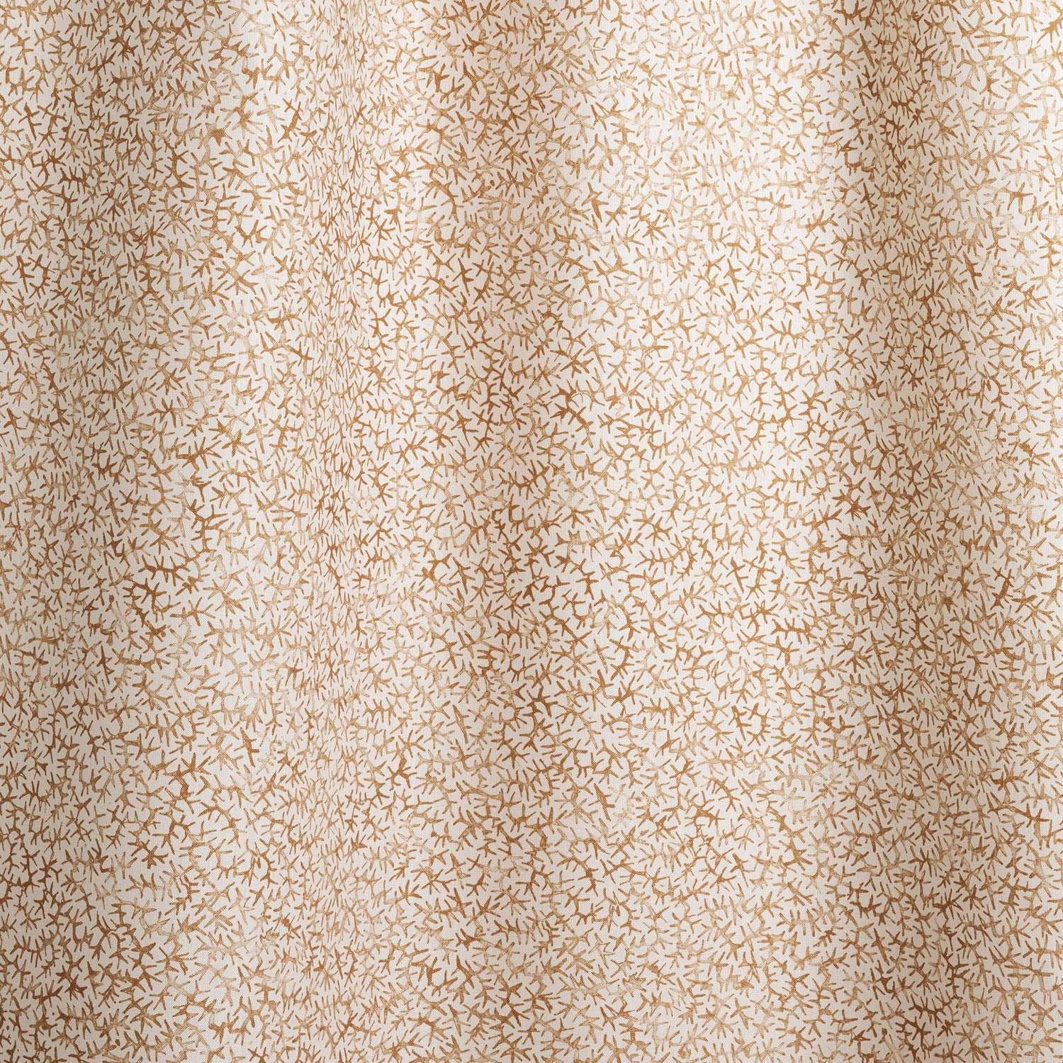 Draped fabric with small scale coral design in warm tan on white. 