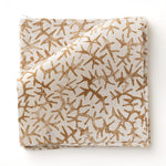 Fabric swatch with small scale coral design in warm tan on white. 