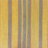 Detail of wallpaper in an irregular stripe print in shades of brown, yellow and coral.