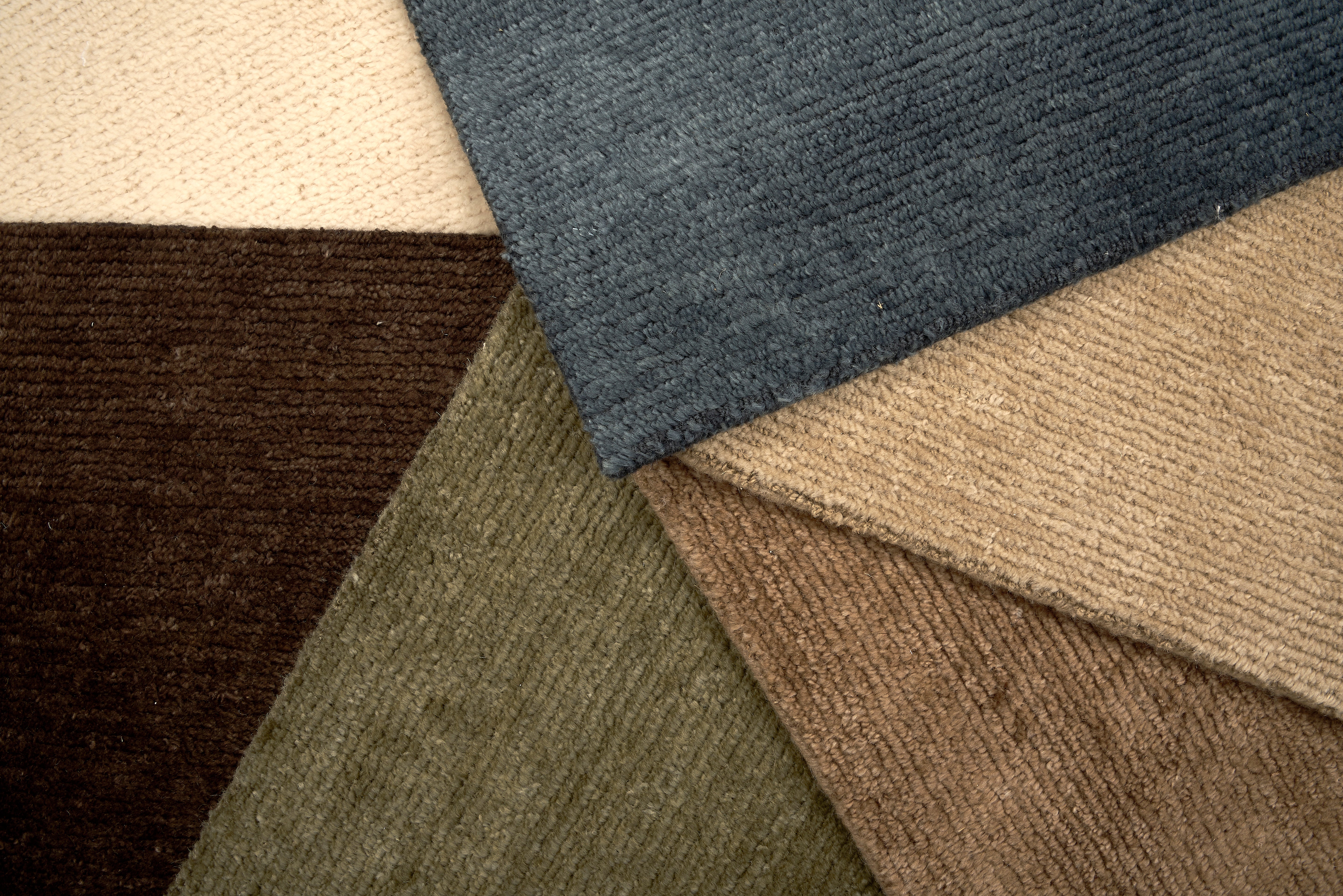 Group of solid luxe broadloom carpets in rich colors. 