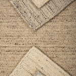 Stack of strié textural broadloom carpet in a range of neutral tones.