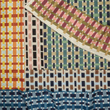 Gently draped fabric cuttings with a graphic plaid pattern in various colors. 